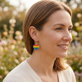 Person wearing rainbow heart earrings