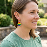 Person wearing rainbow teardrop earrings